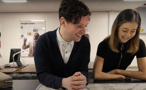 A male and female looking at a map and smiling